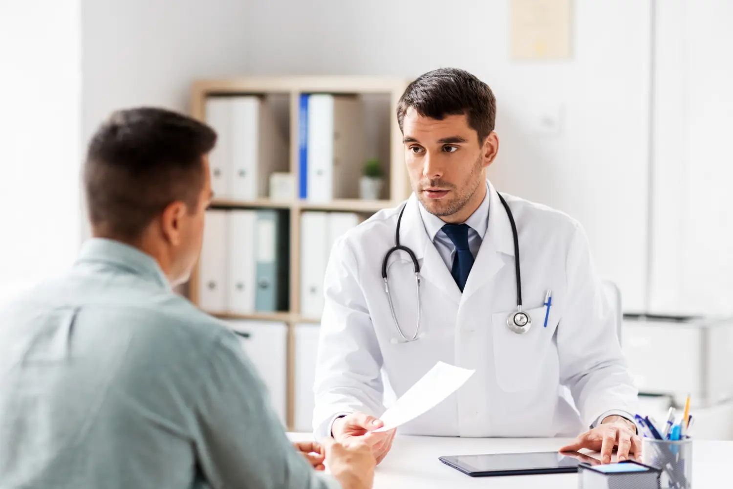 a doctor offering a prescription to a patient