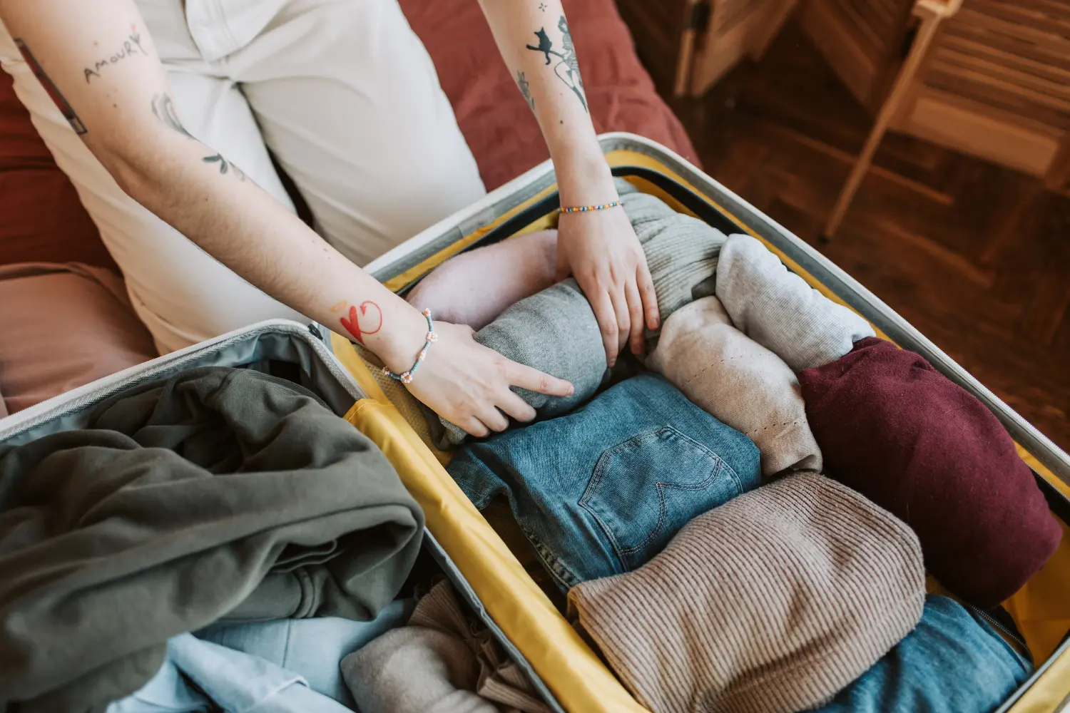 a person packing their suitcase with clothes