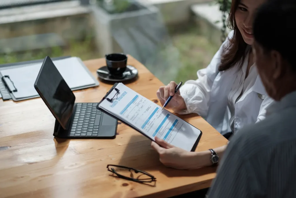 a woman offering a man a health insurance application