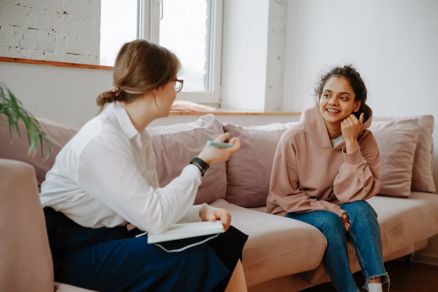 a woman talking to her therapist as they sit together on the couch