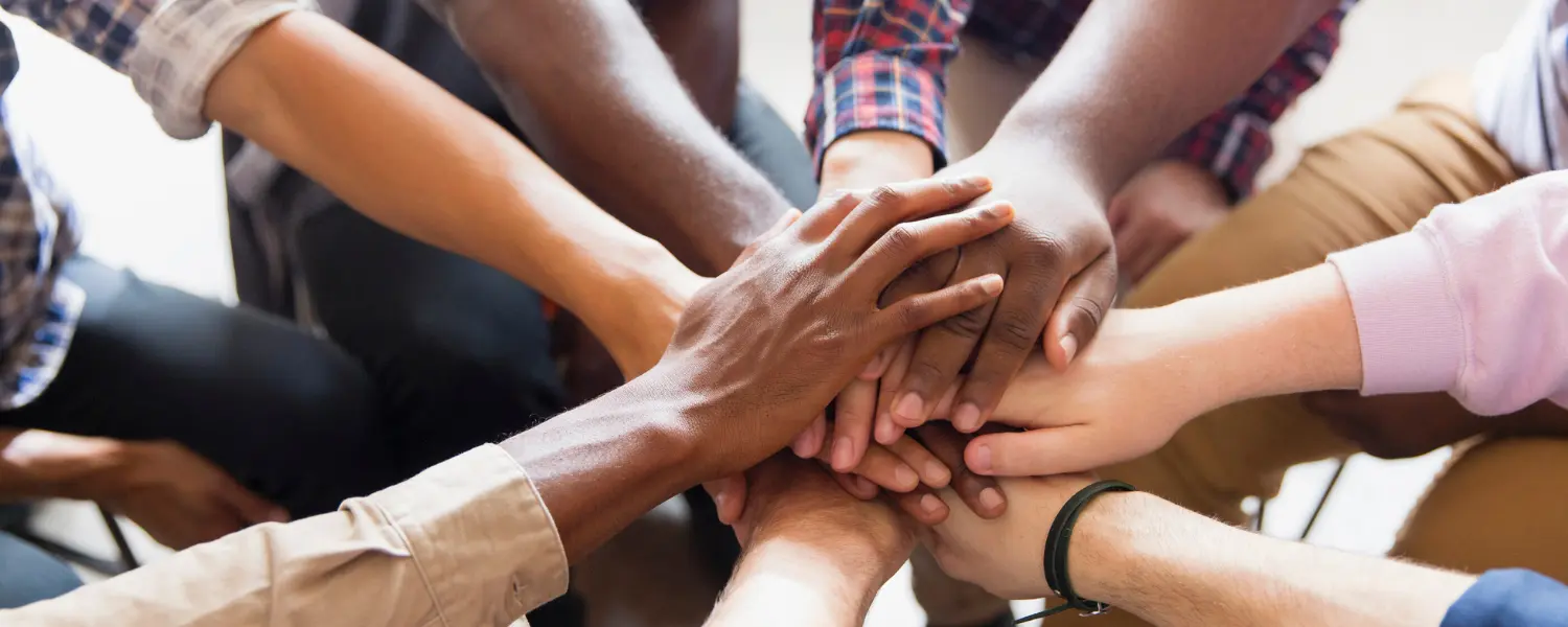 diversity and inclusion - a group reaches out their hands to one another in support of diversity