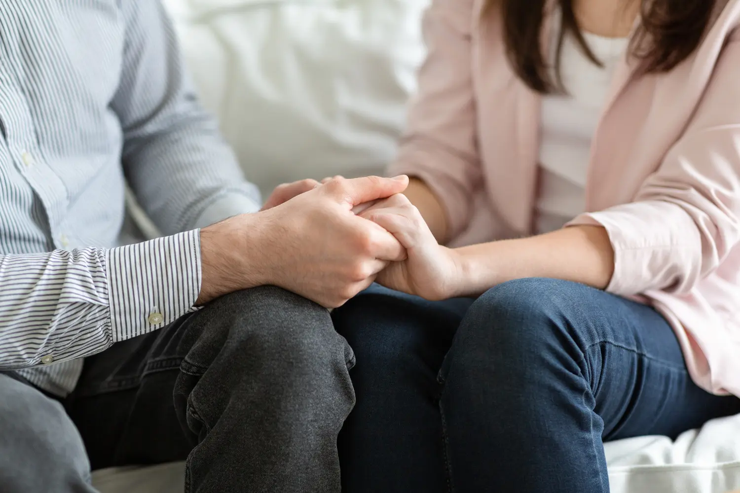 family members hold hands in therapy