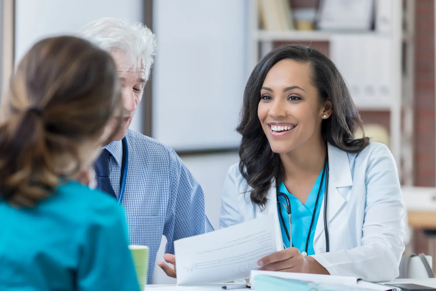 three healthcare professionals talking at a table