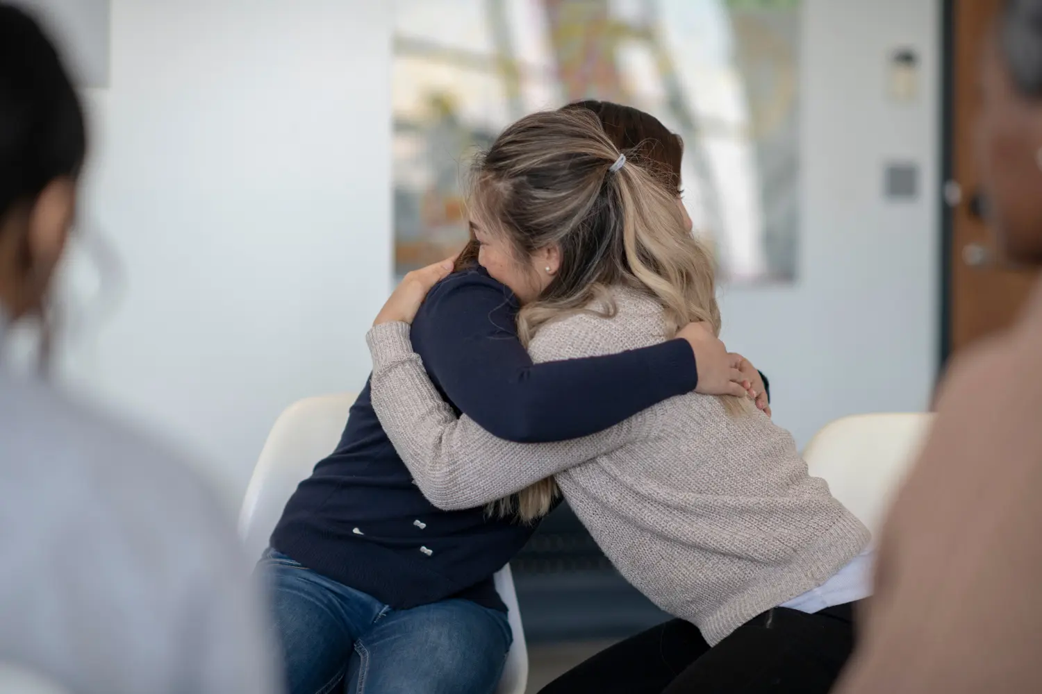 two women hug after group therapy