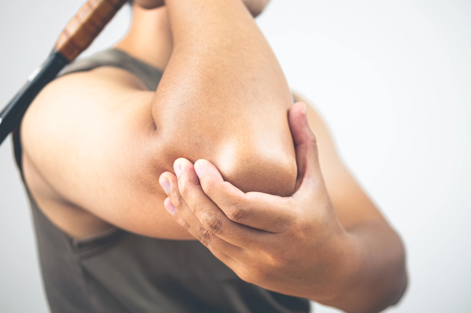 person grips their painful elbow
