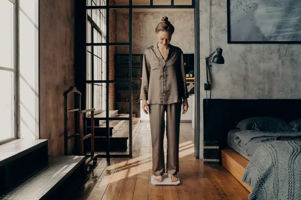 Does Meloxicam Cause Weight Gain? Woman standing on scale.