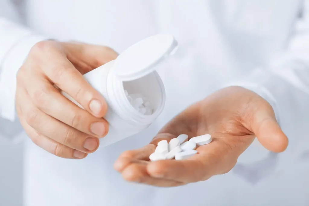 15 mg Meloxicam Equals How Much Ibuprofen? Doctor hands holding white pack and pills.