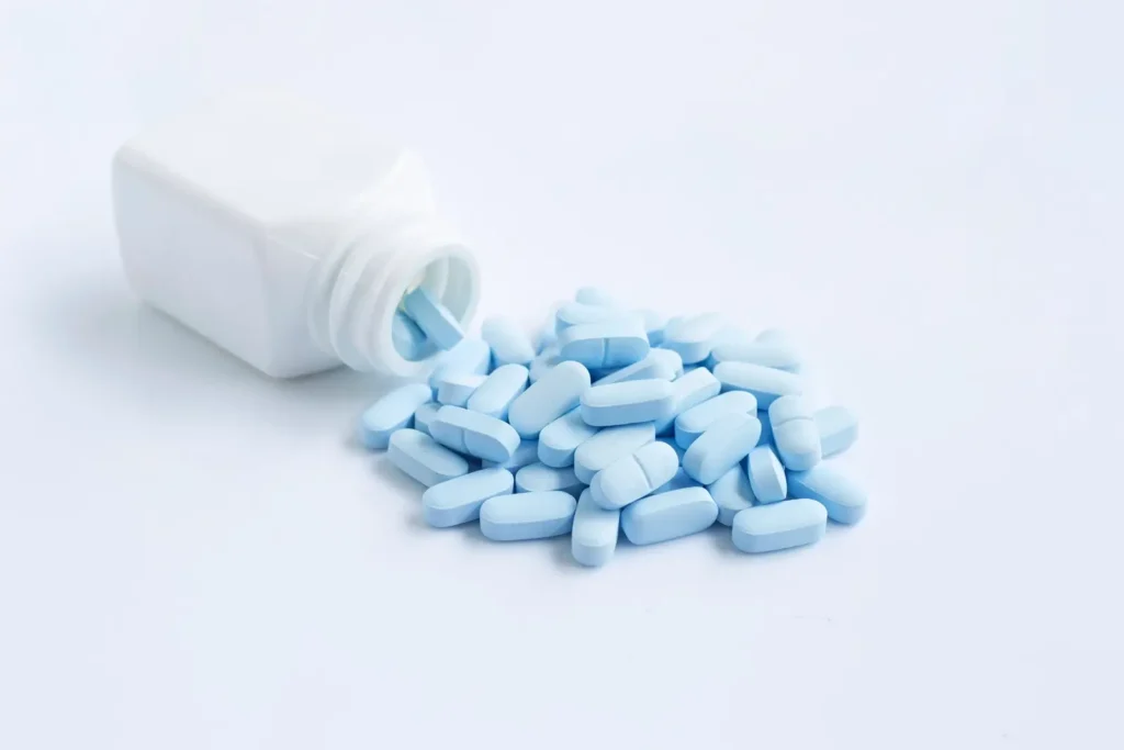 Can You Take Klonopin for Life? Drug Facts, Risks, and More. White bottle with blue pills spilled on a white surface.